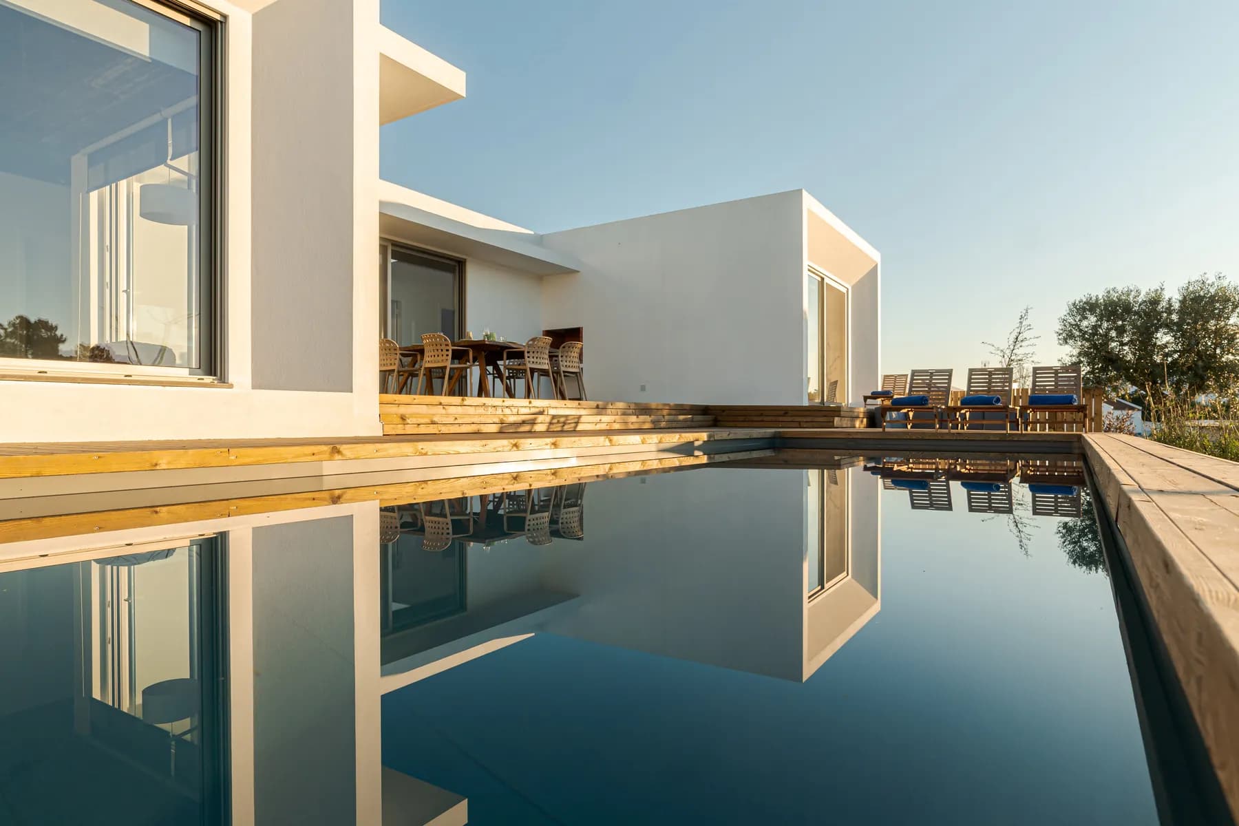 Contemporary white volume mirrored in a still pool